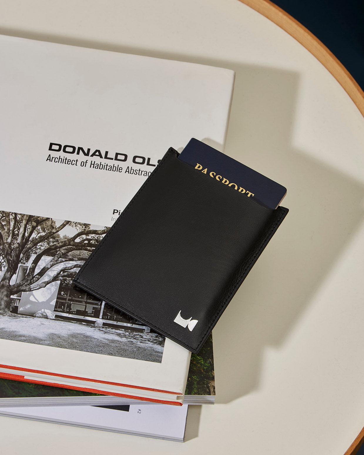 Black leather passport holder sitting on table holding a passport